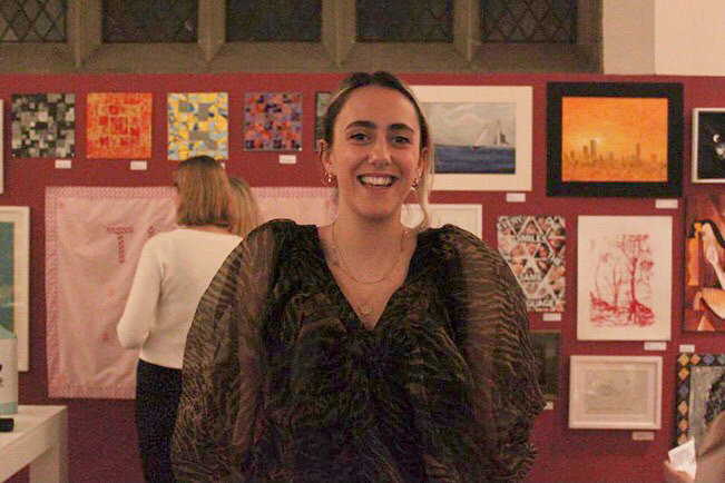 Woman smiling in front of art exhibition